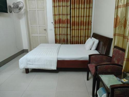 荣市khach san viet uc的一间卧室配有一张床、两把椅子和一扇门