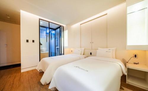 釜山诺埃尔商务汽车旅馆的带窗户的客房内的2张白色床