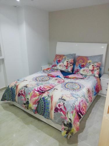阿布达巴Holiday Dream port Ghalib的床上配有色彩缤纷的被子和枕头