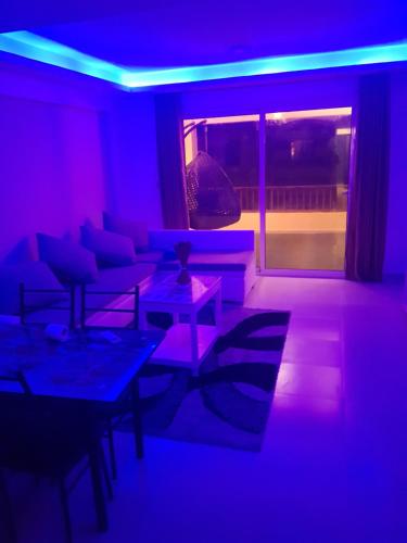 阿布达巴Holiday Dream port Ghalib的一间拥有蓝色和紫色照明的客厅