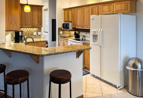 佩吉A quiet, stylish and cozy retreat.的厨房配有白色冰箱和木制橱柜。