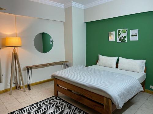 伊斯兰堡Backpackers Hostel Islamabad的一间卧室设有一张床和绿色的墙壁