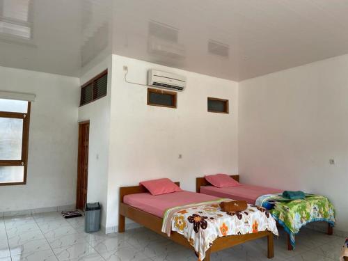 LokokakiRumah Budaya Sumba的一间客房内配有两张床的房间