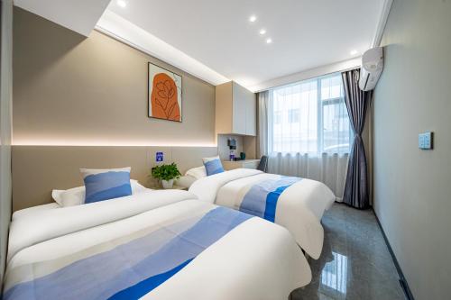 上海优族服务式公寓的配有窗户的酒店客房内的两张床