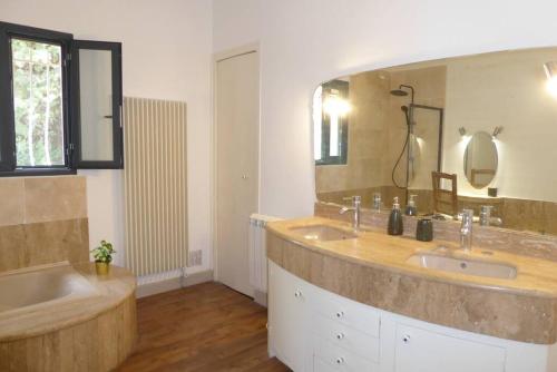 GaronsLa Villa des Pins avec piscine et tennis的一间带两个盥洗盆和大镜子的浴室