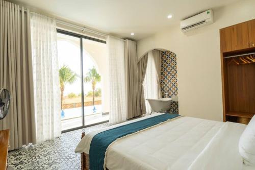 美奈Amanda villa 4 Phan Thiết的一间卧室设有一张大床和一个大窗户