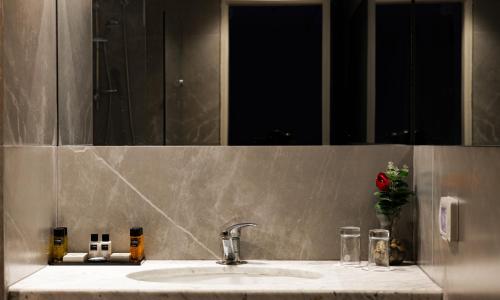 耶路撒冷列夫耶路撒冷酒店的浴室水槽设有镜子和红色玫瑰