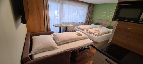 安纳贝格-伦格茨Alpenhaus Donnerkogel的小房间设有两张床和电视