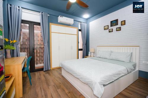 河内JOY APARTMENT TAY HO的一间卧室配有一张床、一张书桌和一个窗户。