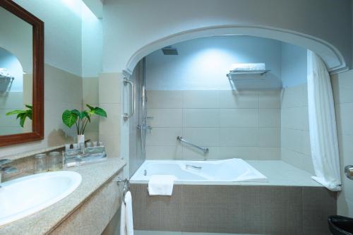 利帕芒特马拉拉亚套房酒店的白色的浴室设有浴缸和水槽。