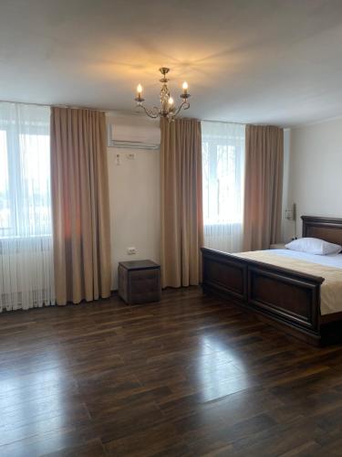 BrzezhanyЕдем的一间卧室配有一张大床和一个吊灯。