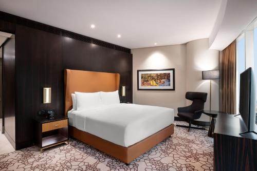 利雅德Hilton Riyadh Olaya的一间卧室配有一张床、一张桌子和一把椅子