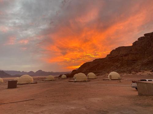 瓦迪拉姆Rum Aranda camp & Jeep Tour的一群沙漠中的圆顶,日落