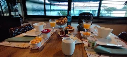 波尔尼克Claire & Co Chambre d'hôtes的桌子上放有盘子和橙汁杯