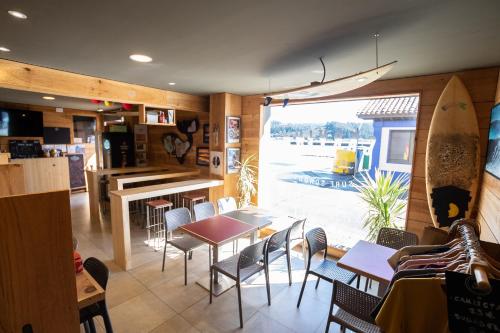 San Esteban de PraviaCarving Surf Hostel的一间带桌椅和冲浪板的餐厅