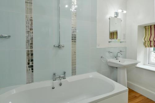 Exford王冠酒店的白色的浴室设有浴缸和水槽。