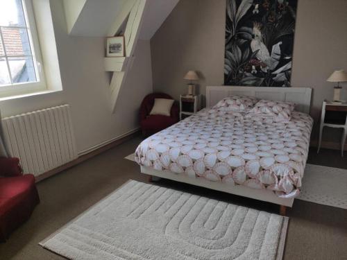 Tourville-sur-SienneChambre d'hôtes的一间卧室配有一张床和一张红色椅子