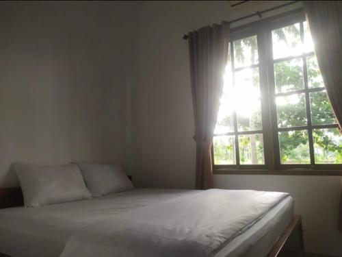 巴图卡拉Puri Sanghyang的一间卧室设有一张床和一个窗口