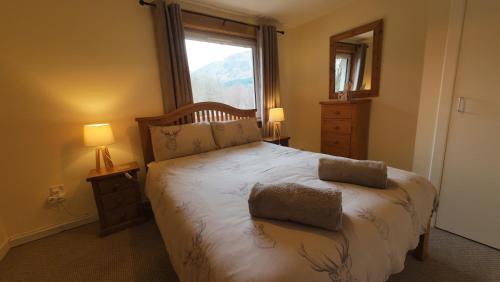 格伦芬南Number 4, Loch Shiel View的一间卧室设有一张大床和窗户