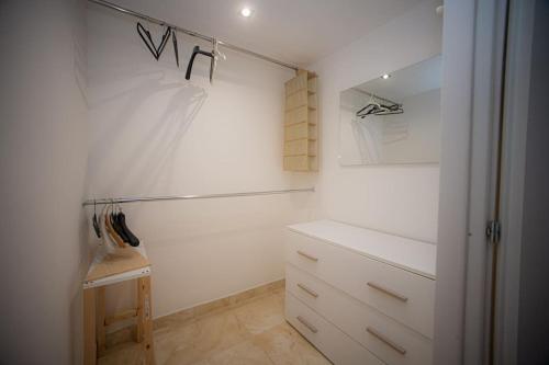 丽都迪奥斯蒂亚Appartamento La Coccinella的客房设有带白色橱柜和抽屉的衣柜。