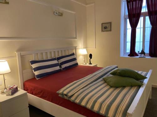 安曼The 1st Night Hotel的卧室配有带枕头的床铺和窗户。