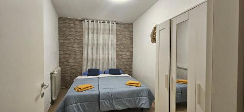 蒙法尔科内NICROB的一间卧室配有一张带蓝色床单和黄色枕头的床。