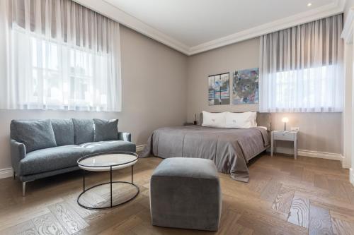帕兰加Vila Komoda的一间卧室配有一张床、一张沙发和一张桌子