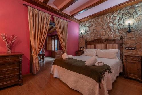 阿尔巴拉辛酒店 - 普拉多那瓦佐餐厅的一间卧室设有一张大床和石墙