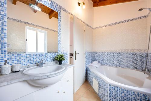 阿尔热祖尔AnchorHouse Portugal的蓝色和白色的浴室设有浴缸和水槽