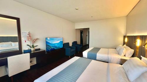 碧瑶Mountain View,Room 549 Private Unit at The Forest Lodge,Camp John Hay Suites的酒店客房设有两张床和电视。