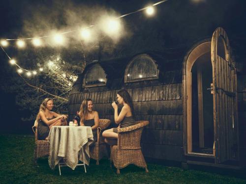 GaißauBodensee Apartments, Sauna, Lake Walks, Free Parking, Self Checkin, Nature Reserve, Restaurants Nearby的坐在房子前面桌子上的三个女人