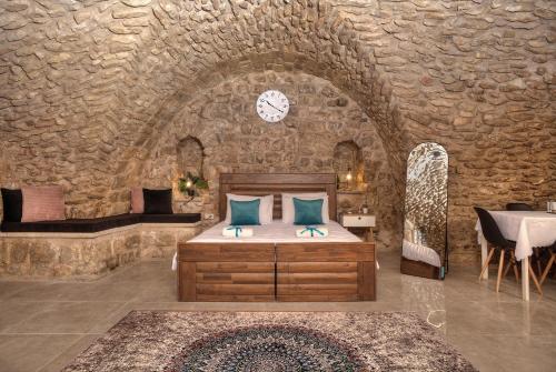 萨法德קשתות - מתחם אבן בצפת העתיקה - Kshatot - Stone Complex in Old Tzfat的卧室配有一张石墙床
