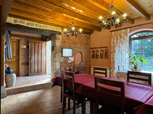 LuzmelaCasa Rural La Socarrena的一间用餐室,配有红色的桌子和椅子