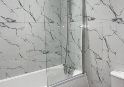弗特威克Flitwick Luxury Apartment的带淋浴的浴室和玻璃门