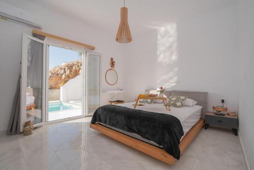 纳克索乔拉Nèsoi Villas Naxos的白色的卧室设有床和大窗户