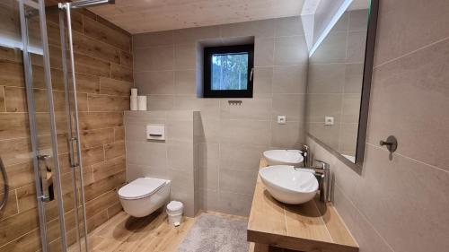 鲁容贝罗克Chalets Hrabovo的浴室设有2个卫生间和玻璃淋浴间。