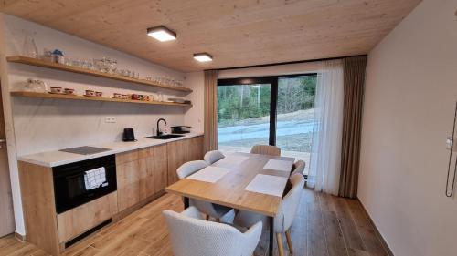 鲁容贝罗克Chalets Hrabovo的厨房以及带木桌和椅子的用餐室。