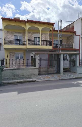 普托莱迈达Polys Apartment and Paraskevi studio with view的街道上带阳台的黄色建筑