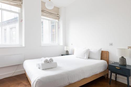 伦敦Lovely 1 Bedroom Apartment Holborn London的白色卧室配有一张大床和两条毛巾
