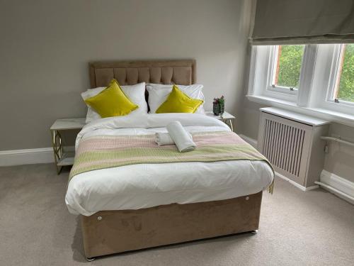 伦敦Central Park Aparthotel的一间卧室配有一张带黄色枕头的大床