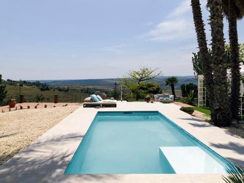 卡尔伦蒂尼Villa Nunziatina的棕榈树庭院内的游泳池