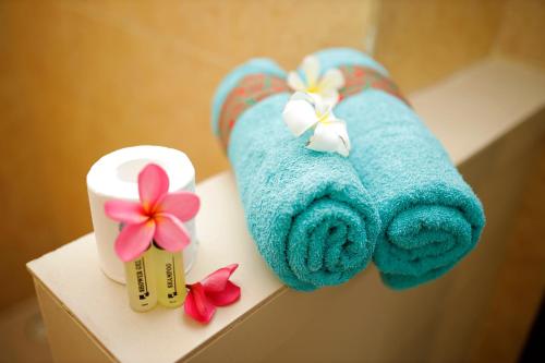 吉利特拉旺安吉利安洋房酒店的两条毛巾,放在带鲜花的架子上