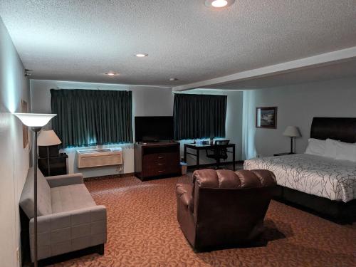 GettysburgGettysburg Inn and Suites的酒店客房配有床、沙发和椅子