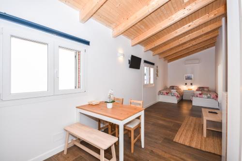马斯诺Acogedora Suite con entrada independiente的厨房以及带木桌和椅子的客厅。