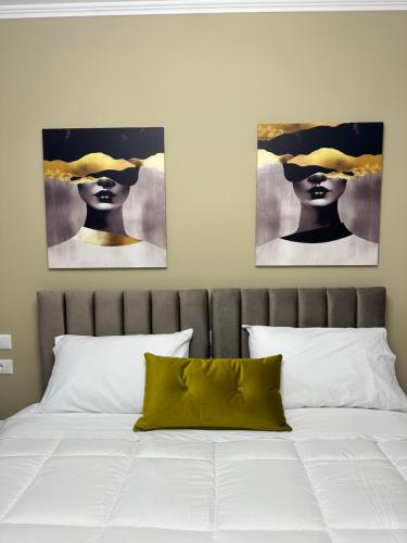 地拉那Horta's home的一间有两幅画作的卧室,画的是一位戴帽子的女人