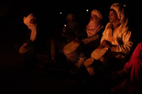 MhamidTaragalte Nomad Camp的一群人坐在黑暗中