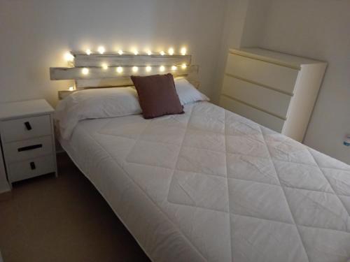 甘迪亚Apartamento Luna的一间卧室配有白色的床和灯。