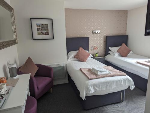曼彻斯特公牛头酒店的酒店客房,配有两张床和椅子