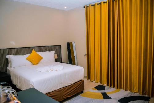 马翁Sewelo inn guesthouse的一间卧室配有床和黄色窗帘