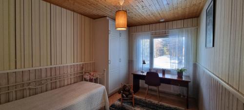 奥卢Peaceful house for relaxing的一间卧室配有一张床、一张书桌和一个窗户。